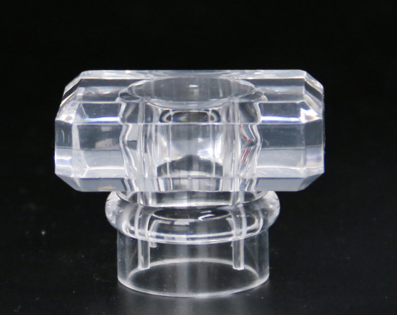 A close-up of a high-quality, transparent acrylic perfume cap on a bottle