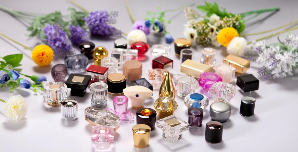 A collage of perfume caps made from different materials like wood, metal, plastic, and glass