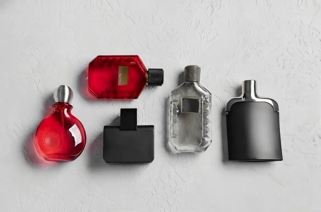 A collection of minimalist perfume bottles with different textures and monochrome colors