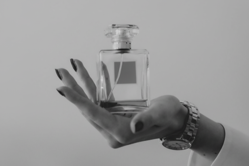 A person holding a standard 50ml perfume bottle in their hand