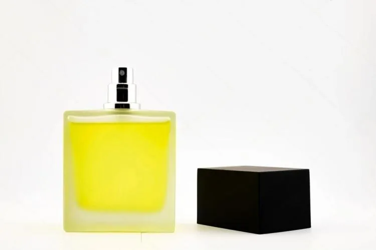 A close-up shot focusing on the texture of a frosted glass perfume bottle