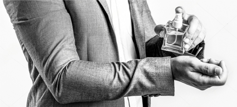 An elegant hand testing a perfume sprayer, showing a fine and even mist