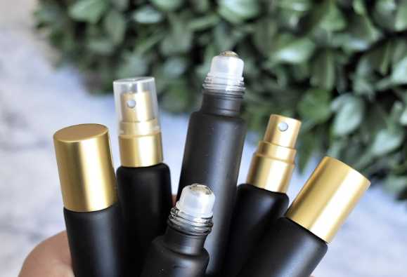 A side-by-side comparison of a perfume bottle with a sprayer and one with a rollerball applicator