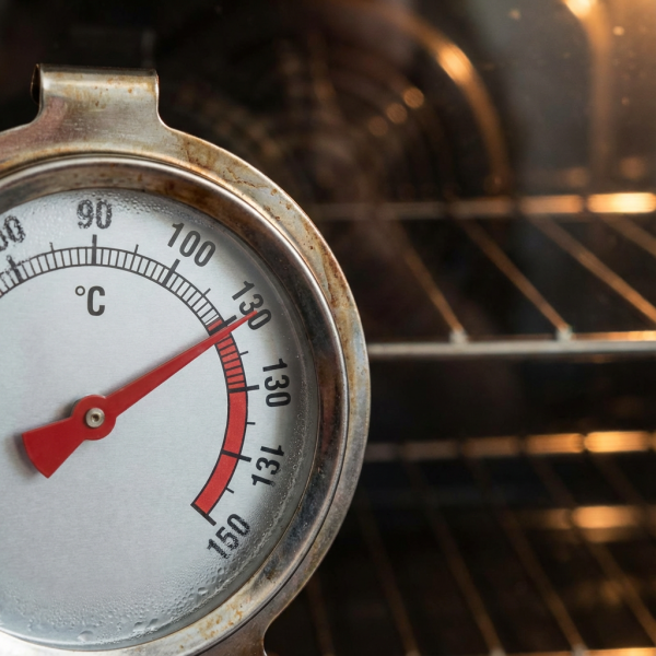 Close-up of an oven thermometer showing 130 degrees Celsius