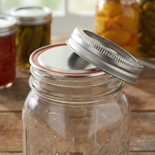 A close-up of a Mason jar's two-part lid, showing the flat disk and screw band
