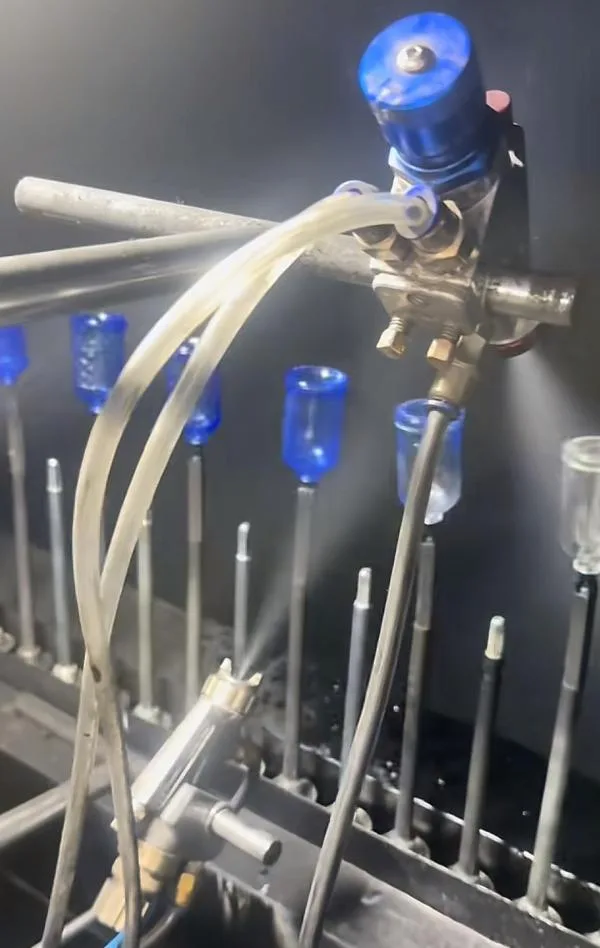 A perfume bottle undergoing a surface finishing process like color spraying