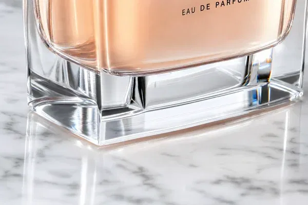 Close-up of a perfume bottle highlighting the thick, clear glass base