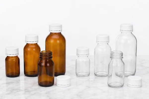 A comparison shot of amber and clear glass pill bottles with white child-resistant caps on a clean background