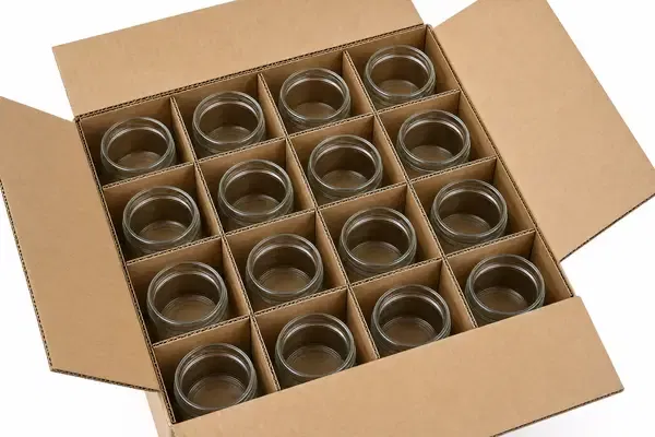 Close-up of double-wall corrugated cardboard dividers creating individual cells for glass jars inside a shipping carton