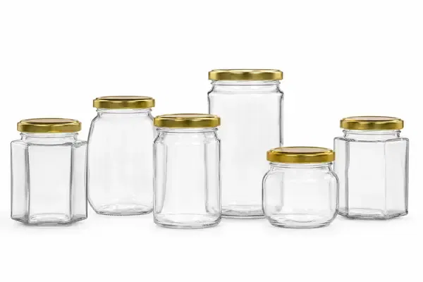 A variety of empty GlassyPack flint glass honey jars, including hexagonal and straight-sided designs, ready for wholesale distribution