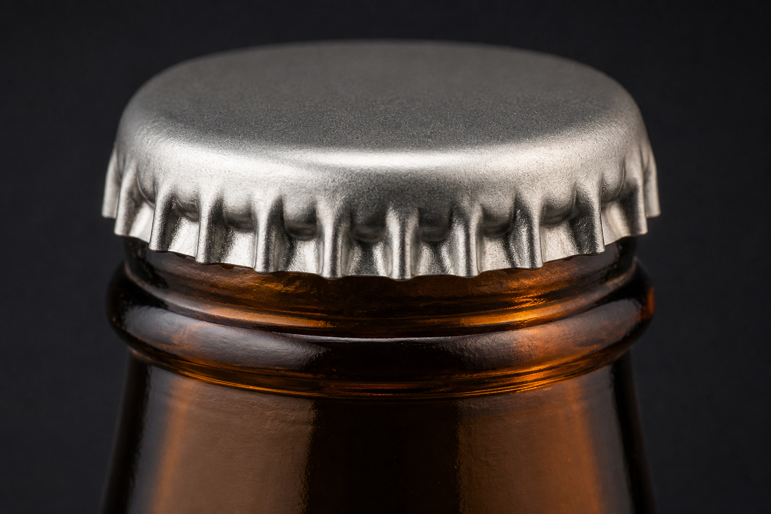 Close-up of a 26mm crown finish on an amber glass beer bottle neck